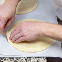 Une fois la galette refermée, il est temps de la décorer ! Une attention particulière est apportée à la bordure qui est ébarbée à l’aide d’un couteau fin. Chez Biosole, on vient la « chiqueter » façon Pithiviers, une spécialité fourrée à la crème d’amande