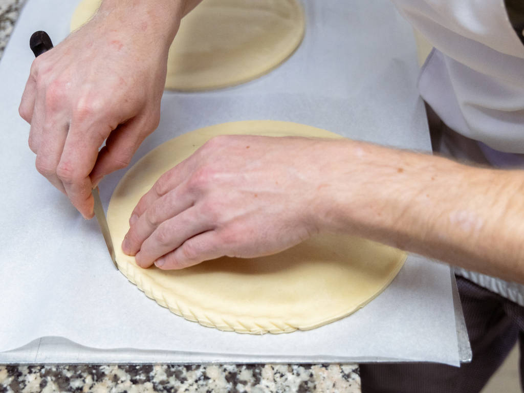 Une fois la galette refermée, il est temps de la décorer ! Une attention particulière est apportée à la bordure qui est ébarbée à l’aide d’un couteau fin. Chez Biosole, on vient la « chiqueter » façon Pithiviers, une spécialité fourrée à la crème d’amande