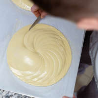 La phase de décoration se poursuit sur la partie supérieure de la galette, toujours à la façon Pithiviers. La galette est ensuite dorée au pinceau avant de reposer au frigo pendant 12 heures. Il est à présent temps de cuire la galette. 